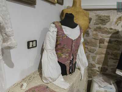Il presidente ci indica subito il pezzo pi� antico: una camicia bianca di fine 700 da ragazzo, con maniche staccabili e sulla quale � posto un panciotto rossiccio con decorazioni floreali